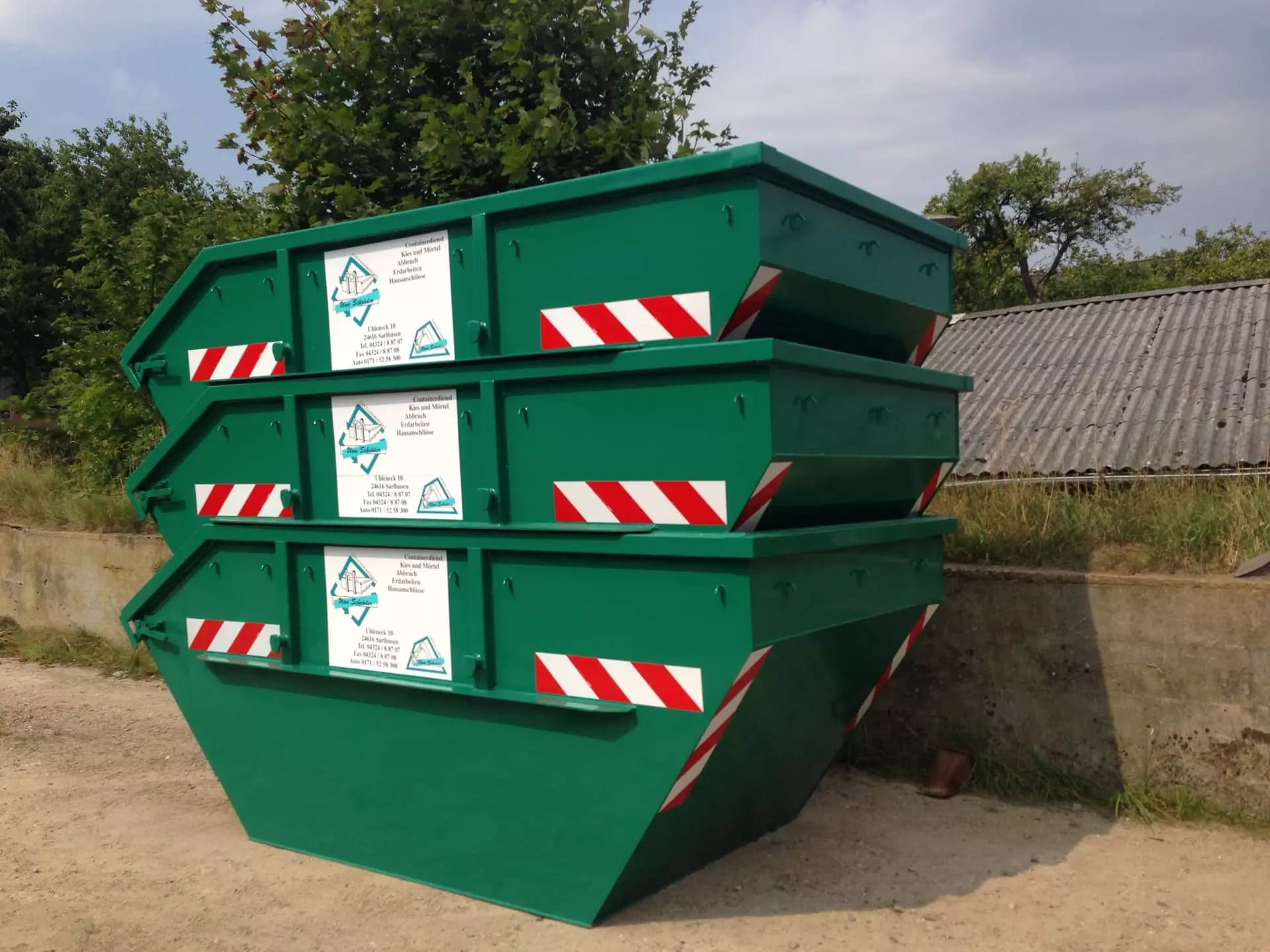 Grüne Absetzcontainer des Uwe Schröder Containerdienst zur Miete für Bauabfälle und Erdaushub