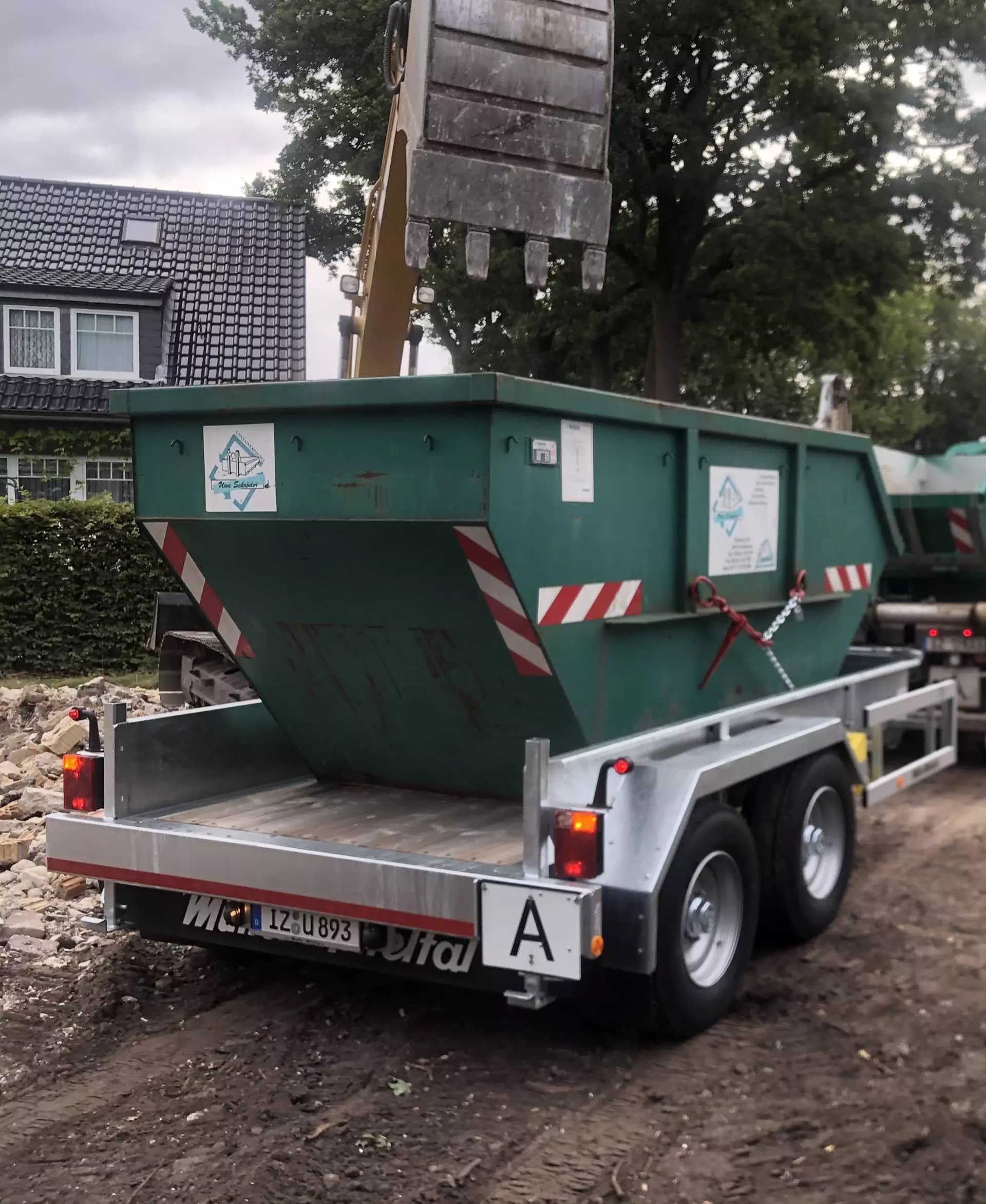 Absetzcontainer auf einem Anhänger des Uwe Schröder Containerdienst vor einem Wohnhaus