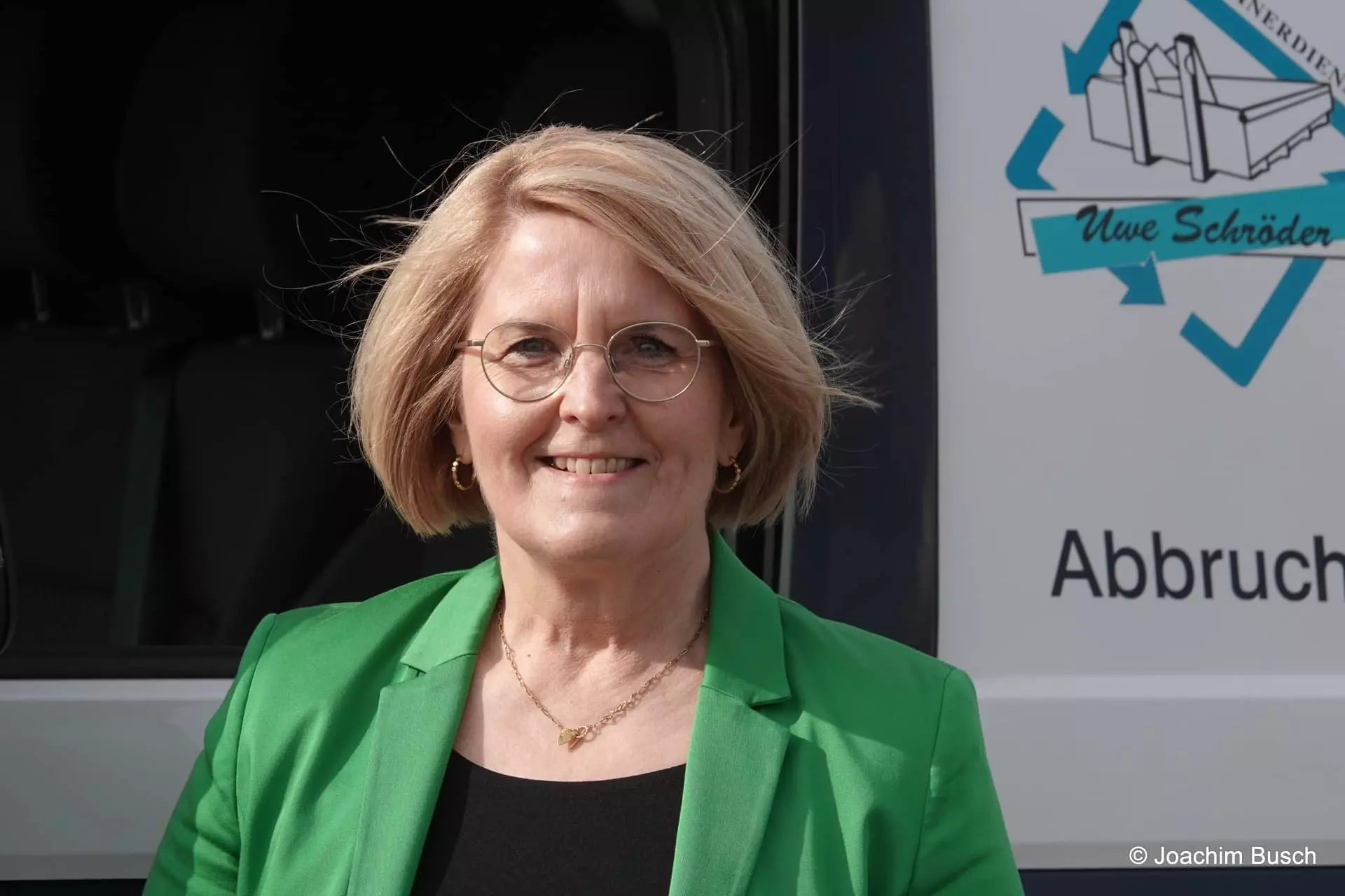 Mitarbeiterin Silke Schröder vor einem Firmenfahrzeug des Uwe Schröder Containerdienst